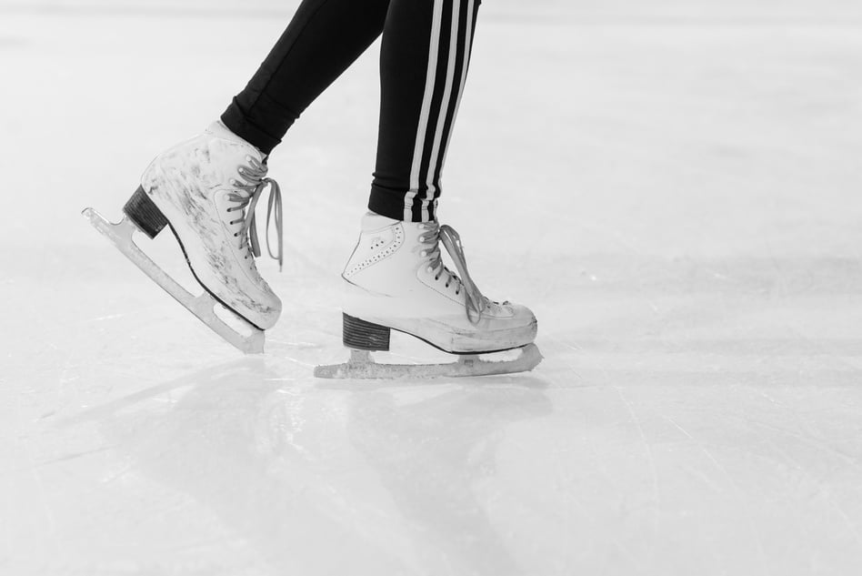 A Person in Black and White Leggings Wearing Ice Skates